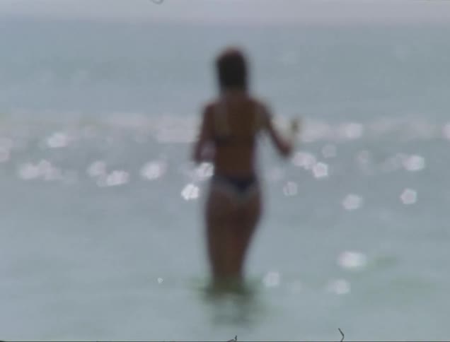 Out of focus shot of a woman in swimsuit on the beach