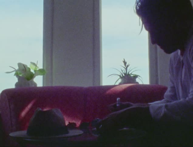 A man sitting in his room thinking and writing