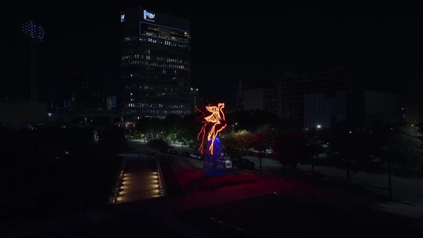 View of a small tower adorned with lights in the midst of a metropolis at night
