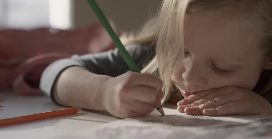 A child is drawing in a book