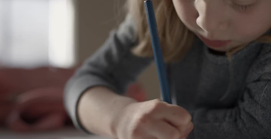 A child is drawing in a book