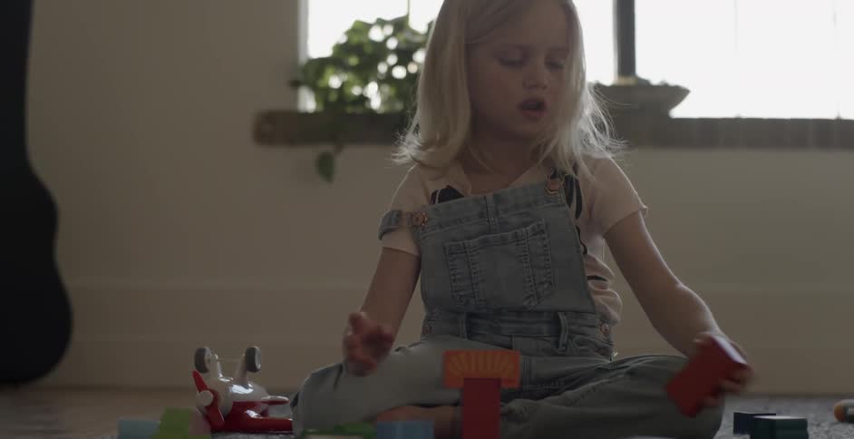A girl is playing with toys on the floor