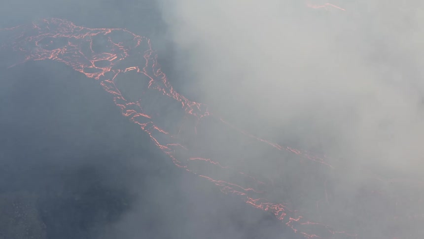 Aerial of an erupting volcano with a lava lake