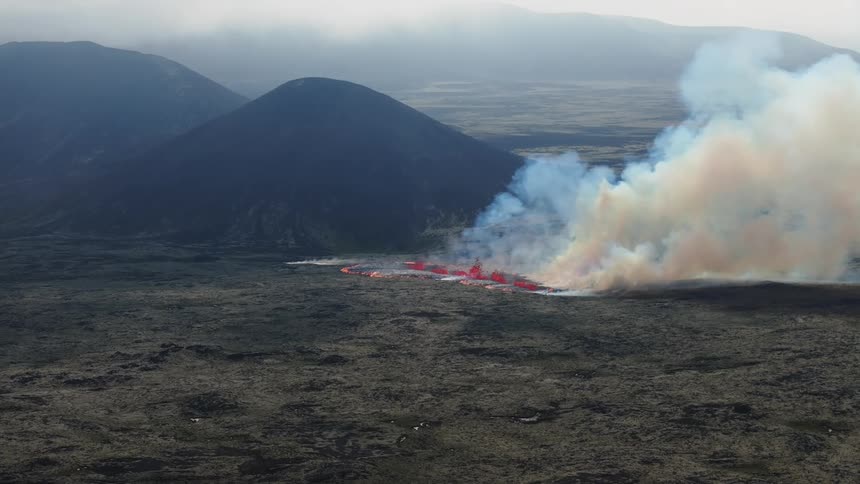 Smoke rises as flaming hot lava flows across the land