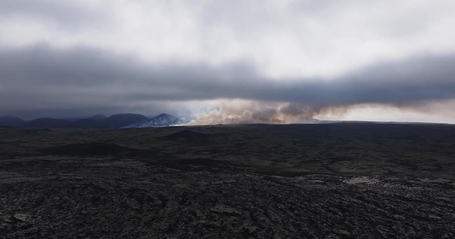 Aerial landscape of a rocky ground flat area next to a mountain range