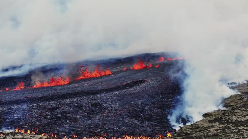 Ground with magma and lava erupting burning the pasture and generating smoke