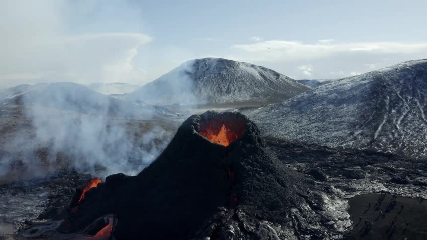 An active volcano spews lava in the mountains