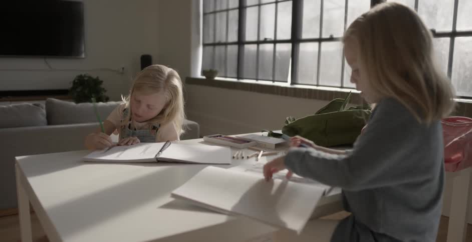 Two children draw in books