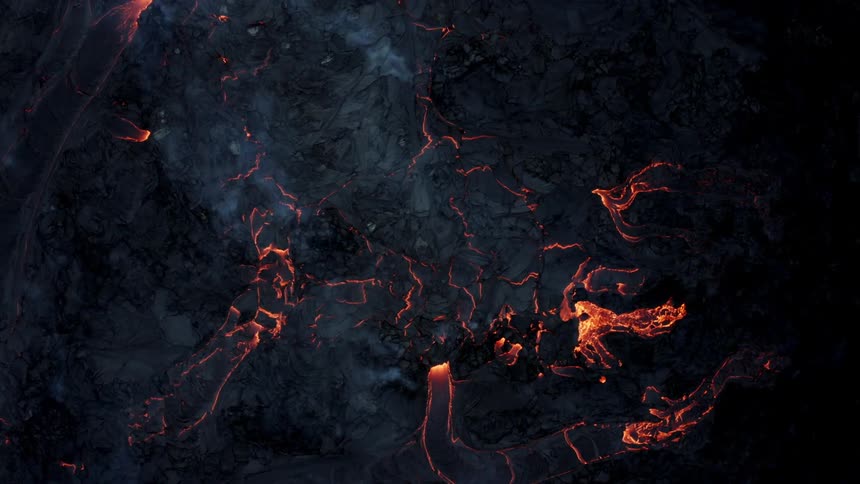 Aerial of smoke rising from ash covered lava