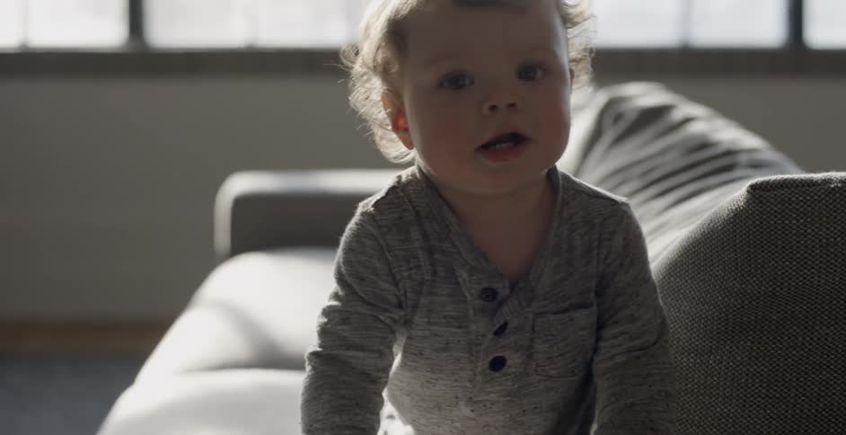 A baby is crawling on the couch