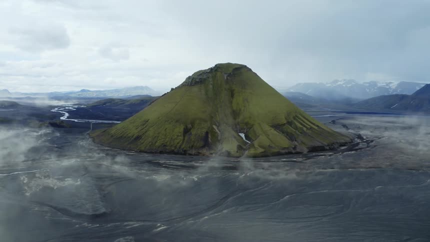 Green mountain with a sandstorm