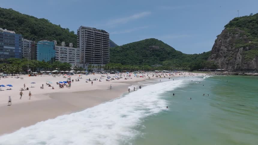 Aerial view of people on the white sand beach near the ocean
