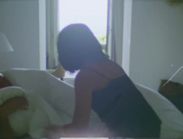 Woman in a short black nightie runs into the bedroom and jumps into bed with her husband and draws the covers over them