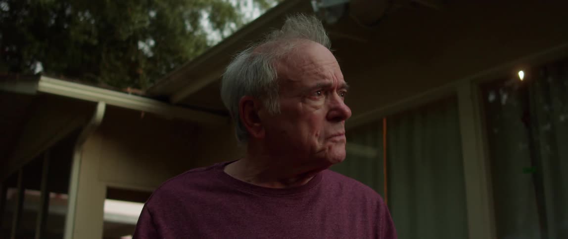 A sad elderly man getting emotional in his backyard