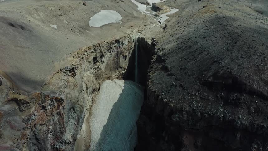 Aerial view of rocky mountains with a waterfall
