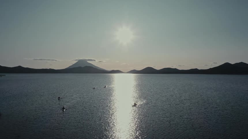 Group of people kayaking in a lake next to the mountains
