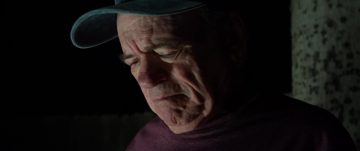 Portrait of an elderly person sitting outdoors at night holding an american flag