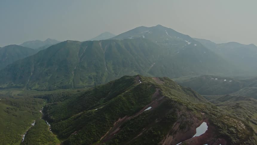 Aerial panorama of mountains and peaks with a light dusting of snow in the morning