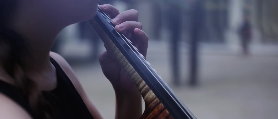 Closeup of a woman playing the violin outdoors