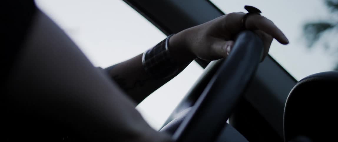 Hand of a person turning the steering wheel of a car