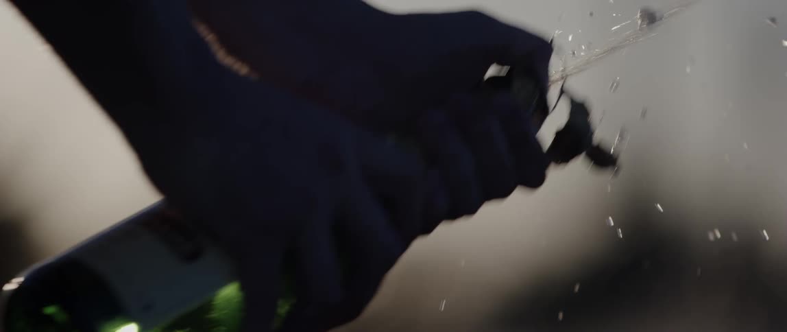 Closeup of a persons hands popping a champagne bottle