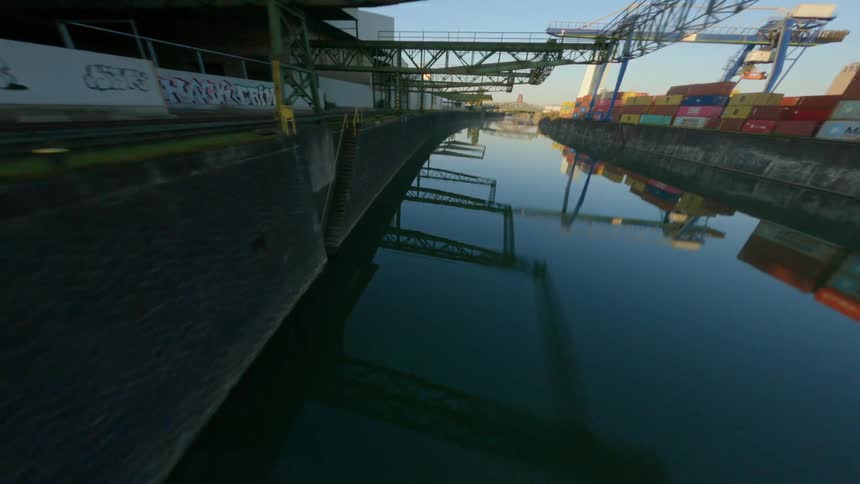 View of a train track next to a port with containers under a morning sky