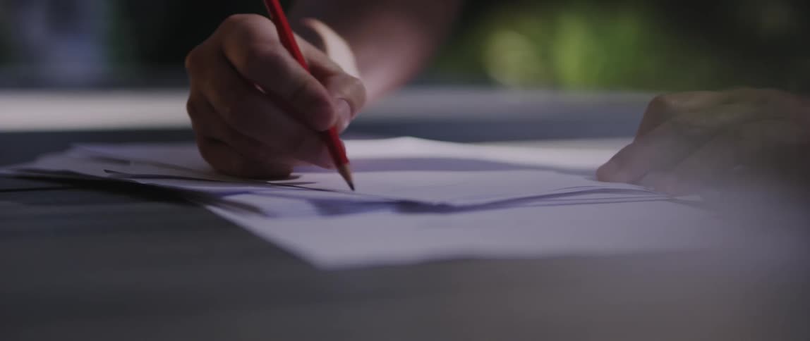 Closeup of a womans hands scribbling on a white paper