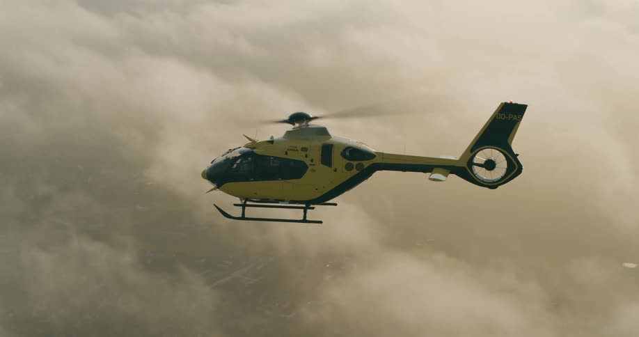 Helicopter flying above the clouds