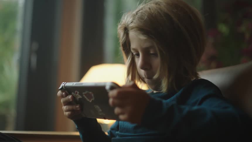 A boy focused on playing video games