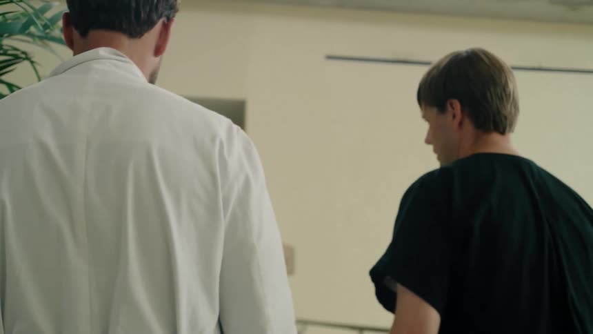 Two men walking side by side in a hallway