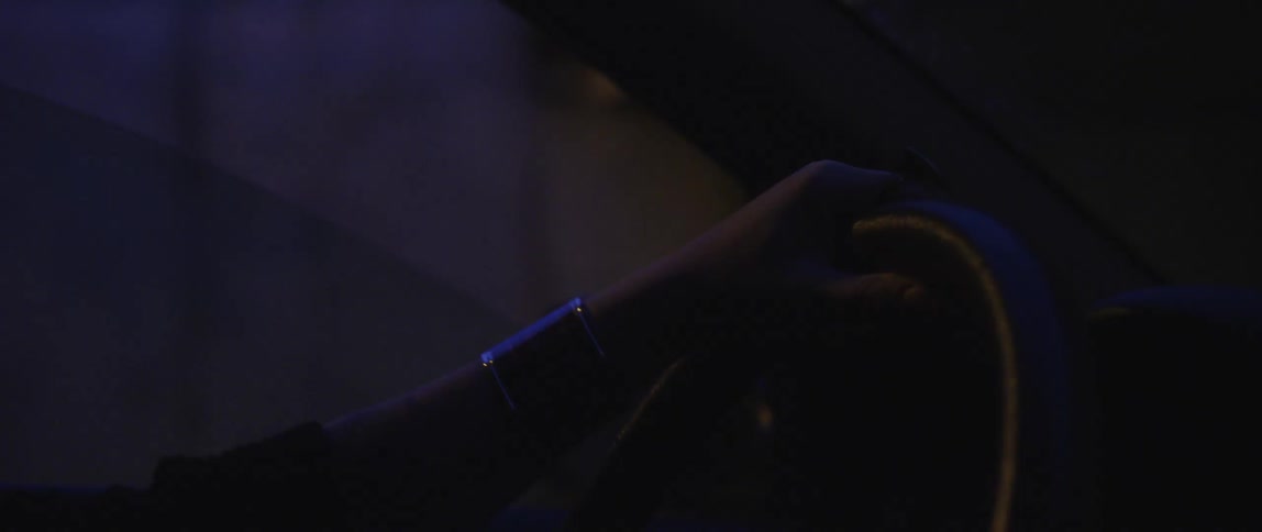 Closeup of a persons hand on the steering wheel driving the car at night