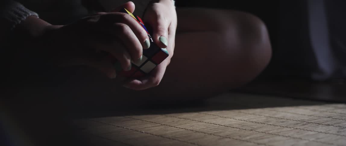 Closeup of a persons hands playing with a rubiks cube