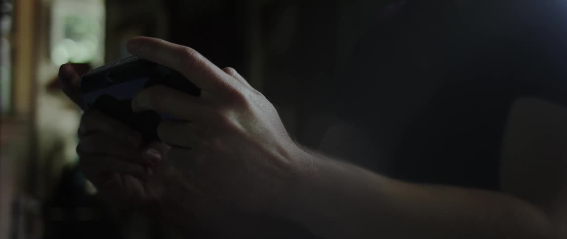 Closeup of a persons hands playing a handheld game