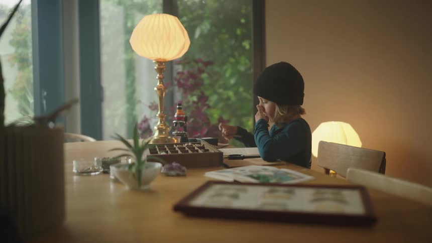 A boy examines some objects with a magnifying glass