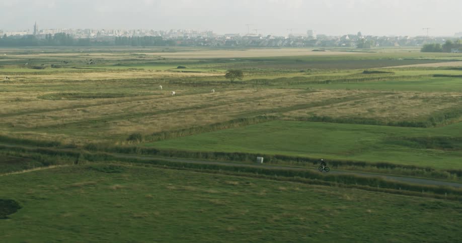 Aerial of a cyclist on the road in a rural town during the morning