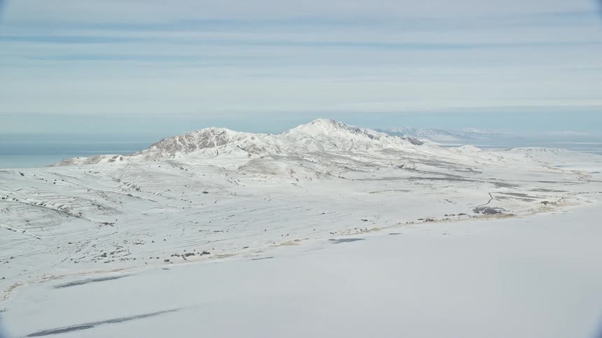 The mountains and field are covered in snow