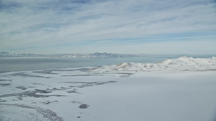 Aerial view of plains and mountains next to the ocean