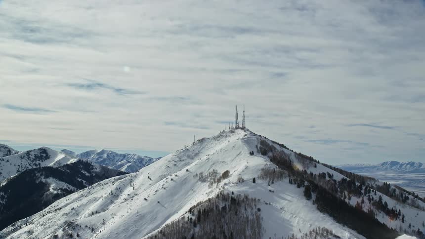 Transmission towers on the peaks of a snowcovered mountain