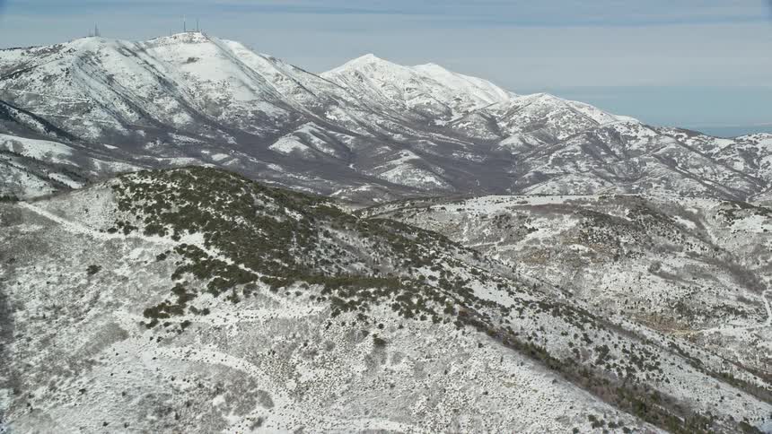An aerial view of a mountain range covered in snow at daytime
