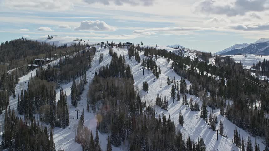 Aerial landscape of mountains with trees covered in snow on a morning