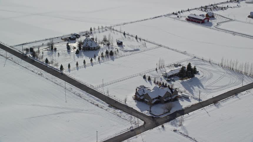 Aerial panorama of houses amidst snowcovered fields