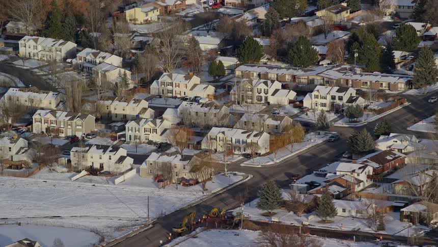 Aerial view of a residential neighborhood with several houses on a snowy winter day