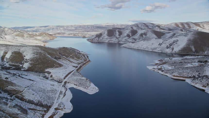 A river runs through the snow filled hills
