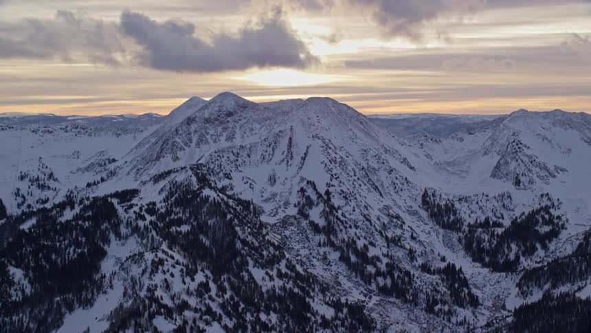 Aerial landscape of a chain of snowcovered mountains with a cloudy sky on a morning