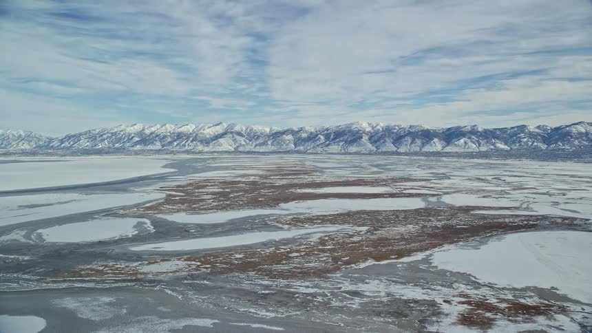 Aerial of plain with frozen lakes and ice mountains during winter