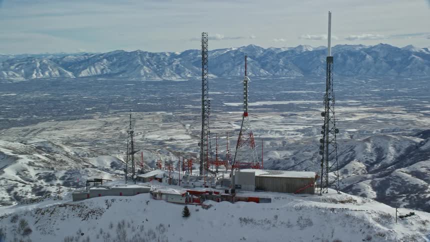 Snowcovered mountain peak with network towers on top