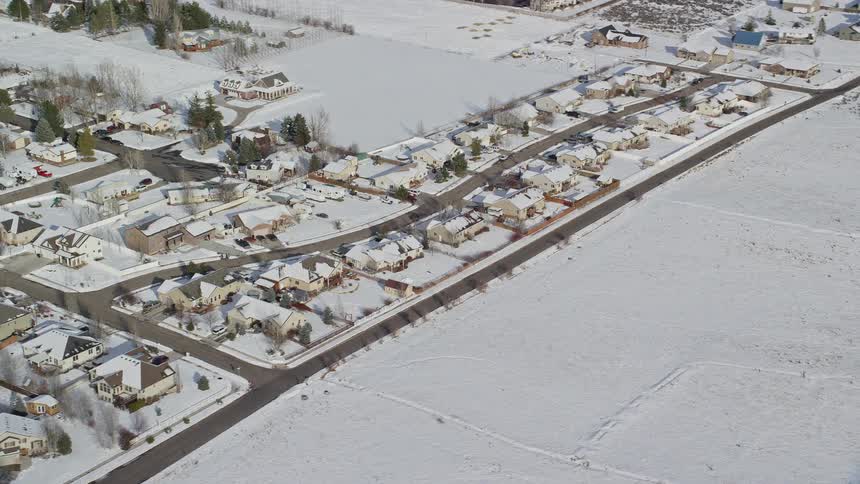 Aerial panorama of a city with residential houses covered in snow and intersections