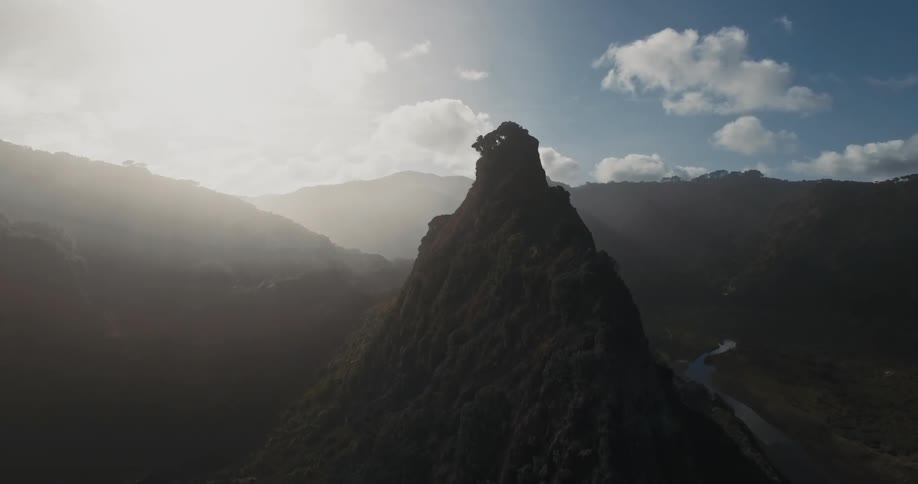View from a cliff on a mountain overlooking a river with the reflection of the sun