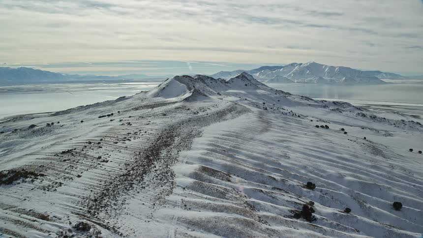 Snowcovered mountains by the sea in daylight