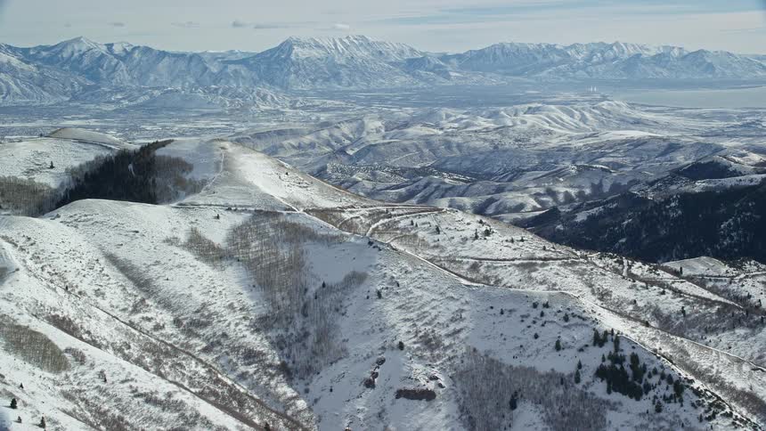Aerial panorama of mountains and peaks with conifers covered in snow on a morning